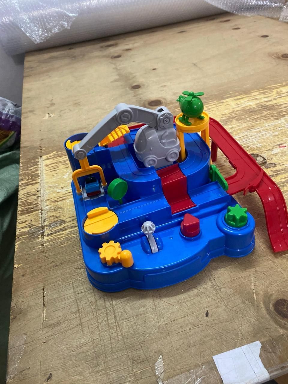 مجموعة ألعاب تعليمية لمواقف السيارات على مضمار سباق، ورافعة، وطائرة، وشاحنة.